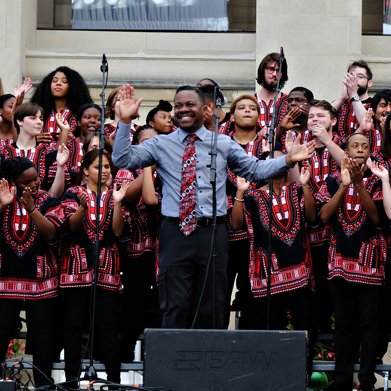 The African American Choral Ensemble performing outdoors on an IU stage