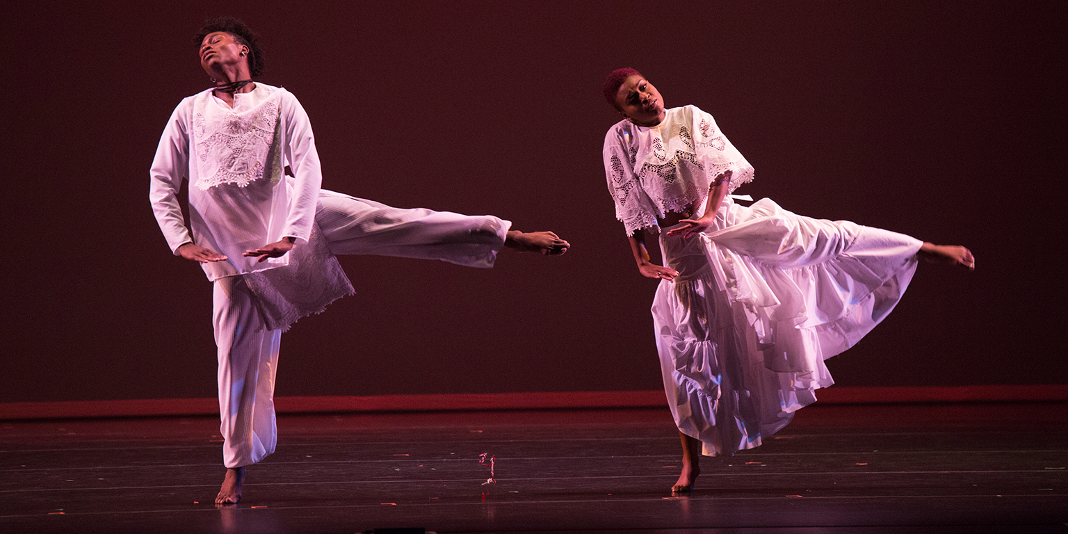 Two performers dance a duet onstage